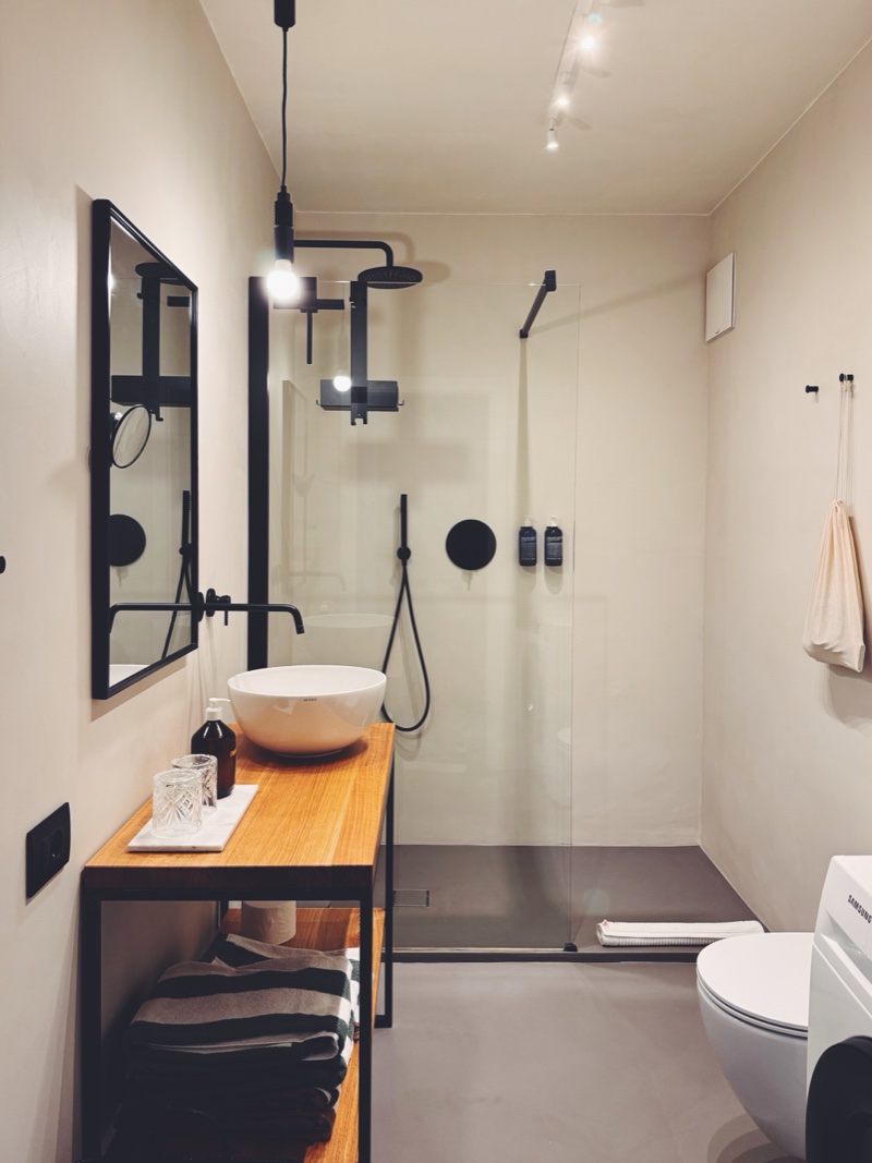 Badezimmer mit Regendusche und schwarzen Armaturen